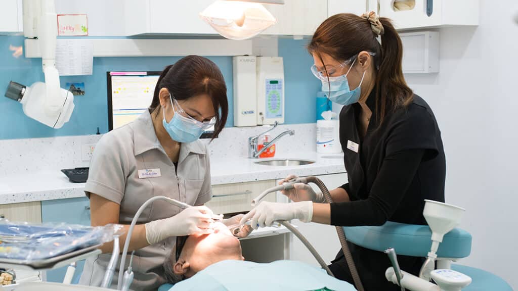 an image of a dentist and her assistant checking up on a patient for dental emergencies at Odin house dental surgery