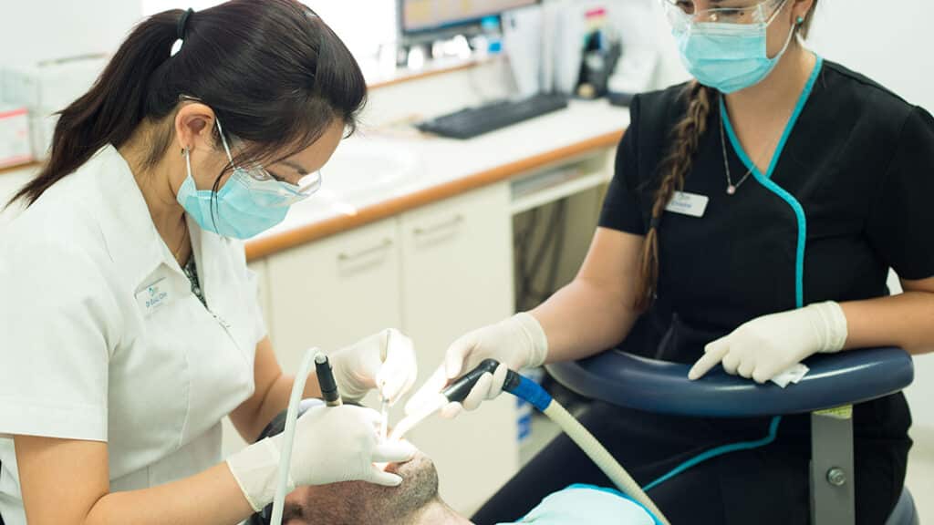 an image of a dentist named dr euli chin checking on a patient at odin house dental